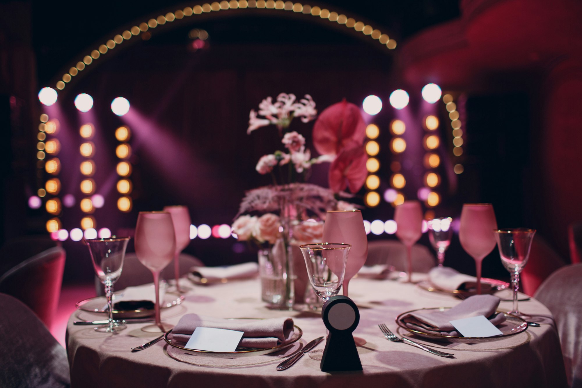 Romantic dinner pink decor table at restaurant with stage